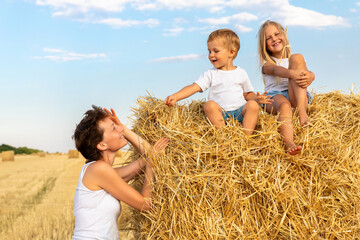 Young adult attractive beautiful mom with little son and daughter enjoy having fun fooling around...