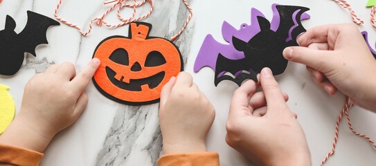 Children siblings sister and brother making decorations for Halloween party celebration. Do it...