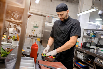 The chef marinates vegetables for grilling