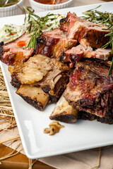 Grilled pork ribs with rosemary and sauces.  Pork ribs BBQ.  The large plate of meat.  Roast pork