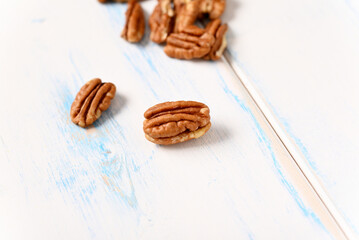 Pecans on a light wooden table.