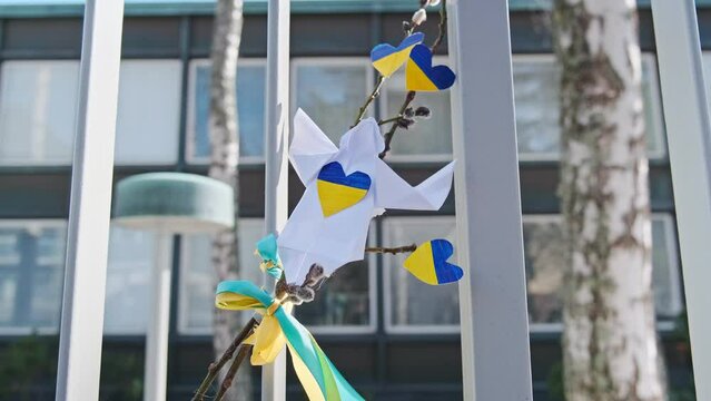 Handmade paper angel with Ukrainian flags on the fence near the Embassy of Ukraine in Helsinki, Finlnad.
