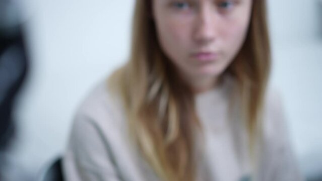 Close-up contactless thermometer showing 36.7 degrees with blurred teenage Caucasian girl at background. Unrecognizable doctor nurse measuring patient temperature in hospital indoors