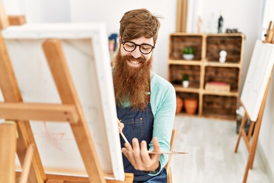 Young redhead man smiling confident drawing at art studio
