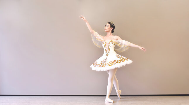 beautiful woman ballet dancer in a white tutu practicing classical dance steps in studio before performance