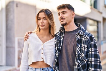 Naklejka premium Young man and woman couple hugging each other standing at street