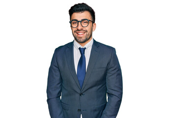 Hispanic man with beard wearing business suit and tie looking positive and happy standing and smiling with a confident smile showing teeth
