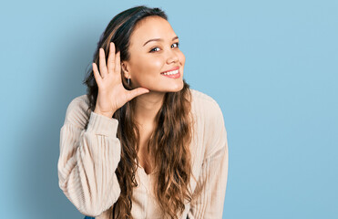 Young hispanic girl wearing casual clothes smiling with hand over ear listening and hearing to...