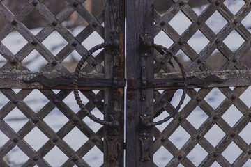 old rusty wrought iron locks and trim forged by a blacksmith on an old wooden gate