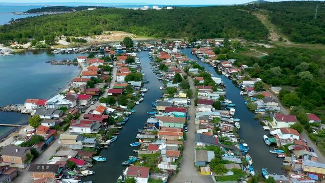 Fishing cottage with boat hus cabins at the ocean or sea on small sandy island. Villages or town of wooden houses in Chengene Skele in Burgas, Bulgaria. Aerial drone flight over a fishing village. Anc
