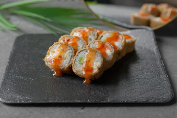 Hot tempura sushi on a gray dish close-up