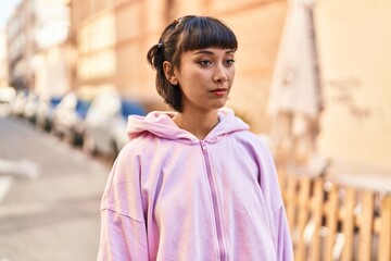 Fototapeta premium Young woman standing with relaxed expression at street