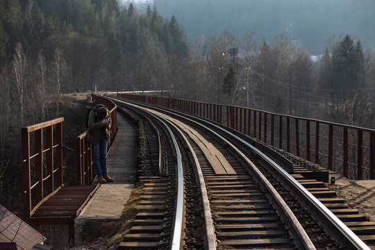 iron rails railway tracks between trees in mountainous terrain in sunny weather in early spring