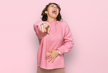 Young hispanic woman wearing casual clothes laughing at you, pointing finger to the camera with hand over body, shame expression - obrazy, fototapety, plakaty