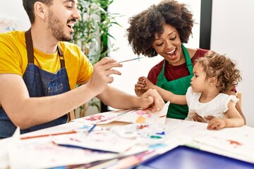 Couple and daughter smiling confident painting child nose at art studio
