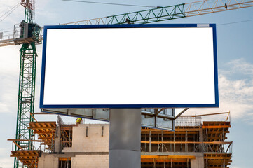 Advertising banner mock-up in front of the residential building under construction. Construction site on a sunny day.