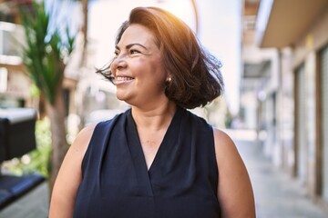Middle age hispanic woman smiling happy and confident outdoors on a sunny day