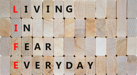 LIFE living in fear everyday symbol. Concept words LIFE living in fear everyday on wooden blocks on beautiful wooden background. Business LIFE living in fear everyday concept. Copy space.