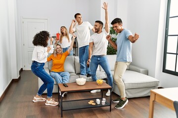 Group of young friends having party smiling happy and dancing at home.