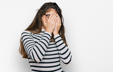 Young beautiful teen girl wearing casual clothes and glasses with sad expression covering face with hands while crying. depression concept.