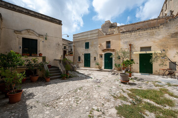 Matera, Basilicata, Italy. August 2021. Pan footage of a courtyard of houses in the historic...