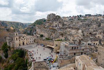 Fototapeta na wymiar Matera, Basilicata, Italy. August 2021. Stunning view with the church of San Pietro Caveoso on the left and the rock church of Santa Maria di Idris further up on the right. Urban landscape of stones.