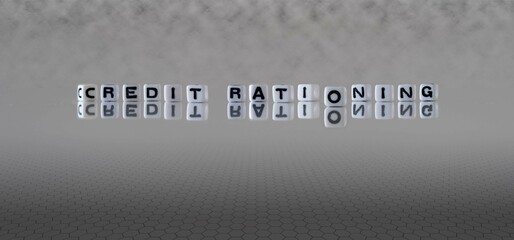 credit rationing word or concept represented by black and white letter cubes on a grey horizon background stretching to infinity