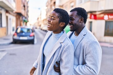 Man and woman couple hugging each other standing at street