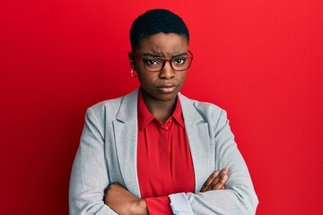 Young african american woman wearing business jacket and glasses skeptic and nervous, disapproving...