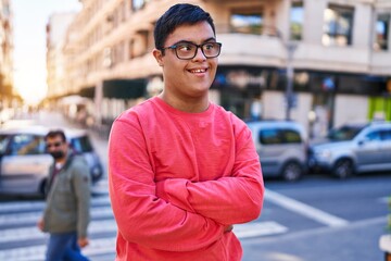 Down syndrome man smiling confident standing with arms crossed gesture at street