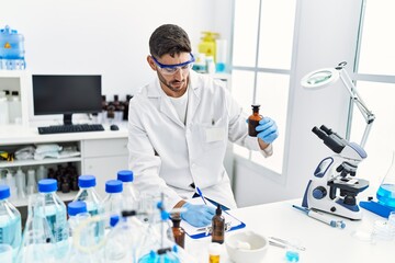 Fototapeta premium Handsome hispanic man working as scientific at laboratory