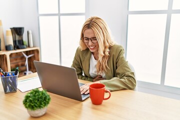 Beautiful blonde woman working at the office with laptop with hand on stomach because nausea, painful disease feeling unwell. ache concept.