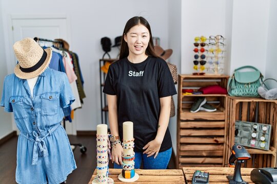 Young Asian Woman Working As Manager At Retail Boutique Winking Looking At The Camera With Sexy Expression, Cheerful And Happy Face.