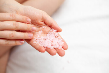 girl on a white sheet doing beauty procedures body scrub