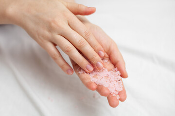 girl on a white sheet doing beauty procedures body scrub
