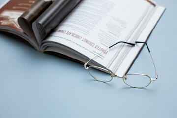 book with glasses pages in the shape of a heart on a gray background