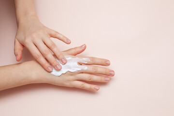cream on hand on pink background