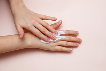 cream on hand on pink background