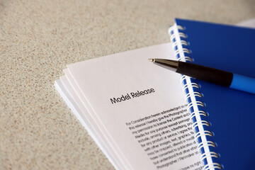 Model release blank form with blue notepad and blue pen lies on photographers table. Model release...