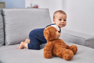 Adorable toddler crowling on sofa at home