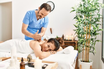 Obraz na płótnie Canvas Middle age man and woman wearing therapist uniform having back massage session at beauty center