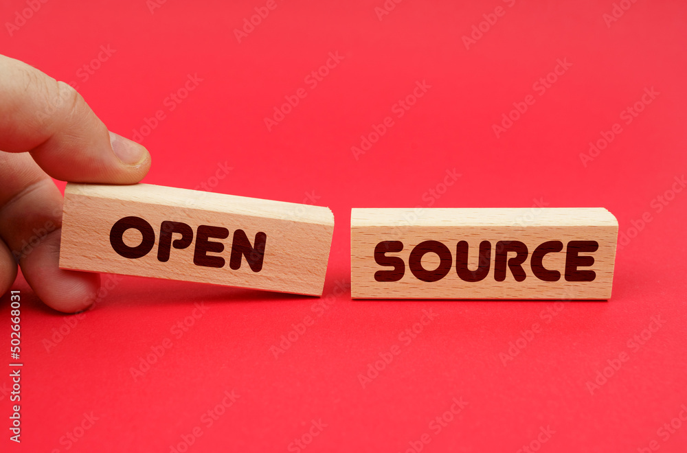 Poster On a red background, wooden blocks, one of them in hand. The blocks are written - OPEN SOURCE