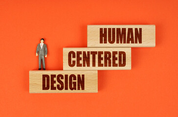 On wooden blocks with the inscription - HUMAN CENTERED DESIGN, there is a miniature figure of a...