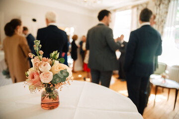 Flowers as a decoration on a table. champagne reception inside. receive guests