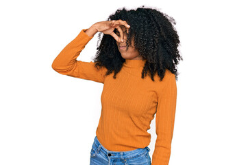 Young african american girl wearing casual clothes smelling something stinky and disgusting,...