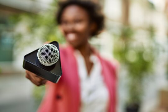 Young African American Woman Journalist Pointing Reporter Microphone To The Camera For Television News