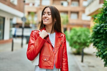 Young hispanic woman smiling happy standing at the city.