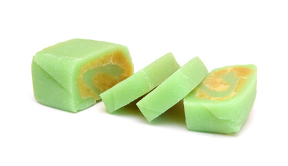 Pieces and crumbs of a homemade Asian sweet cake,  white rice flour and yellow layers of soy cream on white background