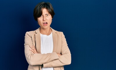 Young caucasian woman with arms crossed gesture in shock face, looking skeptical and sarcastic,...