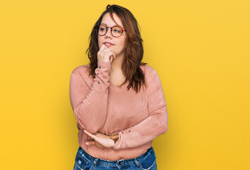 Young plus size woman wearing casual clothes and glasses with hand on chin thinking about question, pensive expression. smiling with thoughtful face. doubt concept. - Powered by Adobe